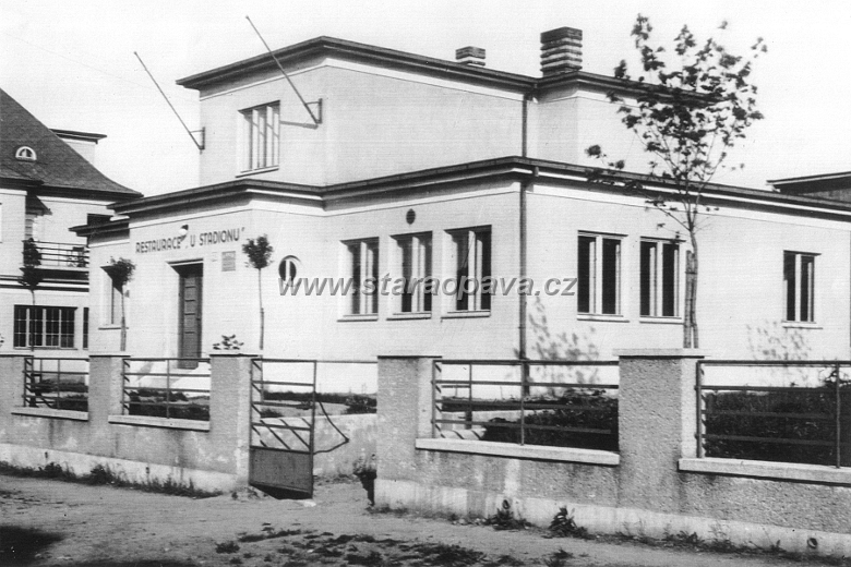 nerudova (19).jpg - Fotografie někdy z přelomu 30. a 40.let 20.století. Stavbu restaurace původním názvem „U Stadionu“ architektonicky navrhl v roce 1935 významný Opavský architekt a stavitel C. Kern (architektonicky upravil a postavil také například budovu České spořitelny v Opavě). Se stavbou se započalo ve druhé půli srpna 1935. Byl zřízen čtyřčlenný stavební výbor ve složení pánů Rýpar, Martiník, Vlček a Král, kteří měli zajišťovat průběh výstavby restaurace. Restaurace je převážně ze dřeva , takže na tesařské práce byla najmuta firma V. Bartoše ze Studénky, práce klempířské a instalaci vodovodu prováděl Oskar Steyer z Opavy, práce stolařské Štěpán Novák z Čavisova, pokrývačské J. Mrůzek z Kateřinek, sklenářské Leo Gross z Opavy, kamnářské firma Harding, zámečnické František Vlček a stavbyvedoucím se stal V. Janečka z Opavy. Restaurace na tehdejší Humelově ulici byla prozatimně otevřena 17. listopadu 1935 za účasti více než dvou set osob. Oficiálně byla posvěcena a slavnostně otevřena v květnu 1936. Restaurace „U Stadionu“ začala sloužit jako klubovna a také jako občerstvovací a stravovací zařízení pro sportovce, kteří docházeli na přilehlý stadion. Po druhé světové válce se v restauraci na Nerudově ulici 25 už s pozměněným názvem „ Na Jízdárně“ stal hostinským Antonín Vícha. Podle tohoto hostinského získává restaurace později třetí a také současný název „ Pohostinství U Antona“.